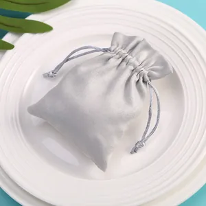 Primer plano de una bolsa de terciopelo plateado con cordón para joyas y regalos