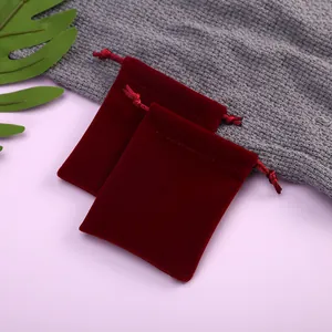 Detailansicht der luxuriösen Textur von zwei weinroten Samtbeuteln mit Kordelzug