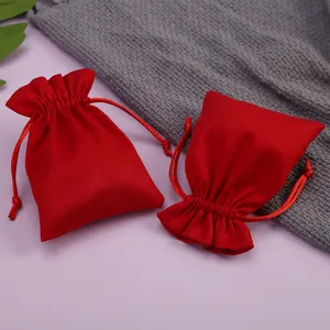 Primer plano de dos elegantes bolsas de terciopelo rojo con cordón para joyas y pequeños regalos