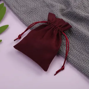 Primer plano de una bolsa de terciopelo burdeos con cordón para joyas y regalos.