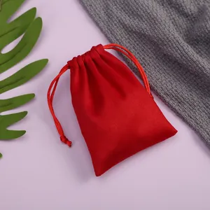 Vista detallada de una pequeña bolsa de terciopelo rojo con cordón para guardar joyas