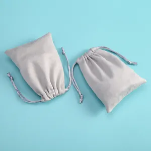 Detailed view of two light grey velvet drawstring pouches for jewelry storage