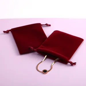 Detailaufnahme roter Samtbeutel mit Kordelzug und einem goldenen Schlangenarmband
