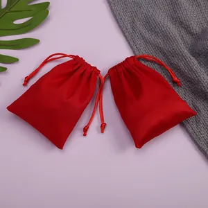 Primer plano de dos bolsas de terciopelo rojo con cordón y suave textura de franela.