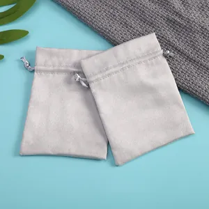 Detalle de dos bolsas de terciopelo gris con cordón para el almacenamiento de joyas.