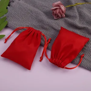 Vista detallada de bolsas de terciopelo rojo con cordón sobre un fondo acogedor.