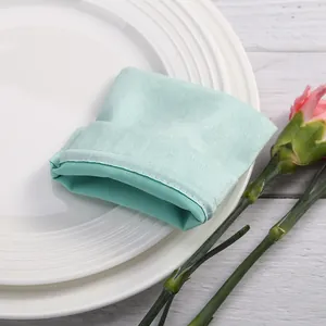 Detalle macro de la suave tela de terciopelo verde menta y costuras en esta bolsa joya