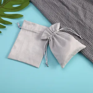 Primer plano de bolsas de terciopelo gris con cordón para joyas y embalaje de regalos