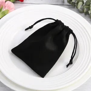 Detalle de una bolsa de terciopelo negro con cordón para guardar joyas o envolver regalos