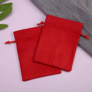 Vista detallada de dos bolsas de terciopelo rojo suave para joyas sobre fondo de lavanda
