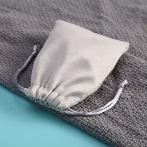 Close-up detail of a soft grey velvet drawstring pouch for jewelry storage and gadgets