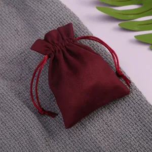 Vista detallada de una bolsa de terciopelo burdeos con cordón para joyas y regalos.