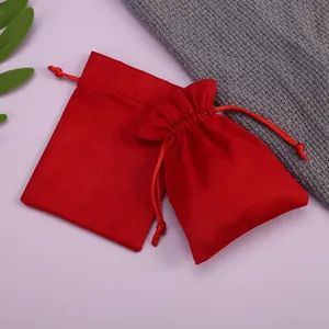 Primer plano de dos pequeñas bolsas de terciopelo rojo con cordón para joyas o regalos