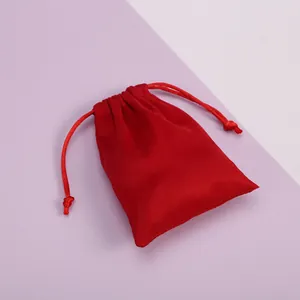 Primer plano de bolsa de terciopelo rojo con cordón para guardar joyas y regalos