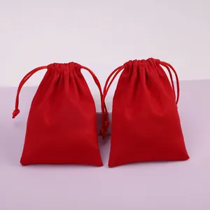 Detalle de dos vibrantes bolsas de terciopelo rojo con cordón para guardar joyas.