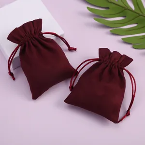 Detalle de dos bolsas de terciopelo burdeos con cordón para guardar joyas y regalos