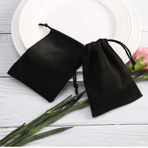 Vista detallada de suaves bolsas de gamuza negra con cordón para joyas o regalos