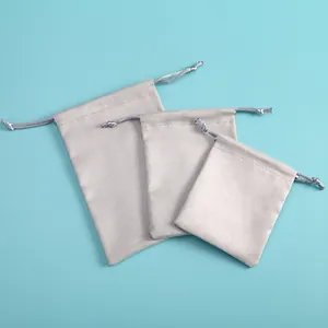 Three sizes of light gray velvet drawstring pouches for jewelry or accessories storage