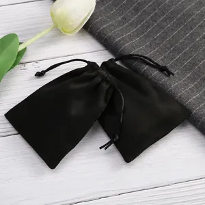 Primer plano de bolsas de terciopelo negro con cordón y suave textura de ante para joyas