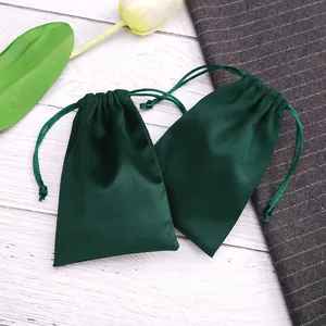 Zwei hochwertige dunkelgrüne Samtbeutel mit Kordelzug für Schmuckverpackungen und Lagerung.