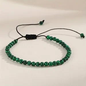 Close-up view of a green malachite gemstone beaded adjustable braided yoga bracelet