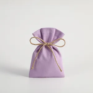 Small purple fabric drawstring pouch with natural jute rope bow for jewelry packaging