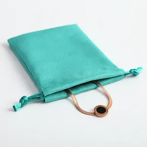Vista detallada de una bolsa de ante verde menta con un collar de oro rosa de moda