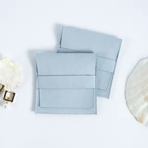 Bolsa de joyería de microfibra de gamuza azul claro con cierre de solapa y textura.