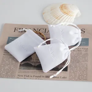 Dettaglio di sacchetti in peluche bianco con coulisse per gioielli e piccoli regali