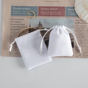Dettaglio di sacchetti in velluto bianco con coulisse e logo Vinknde in rilievo per gioielli