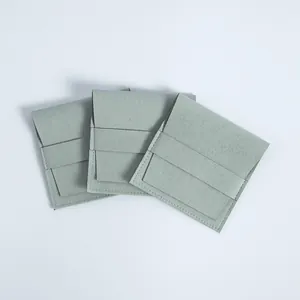 Drei salbeigrüne Mikrofaser-Schmuckbeutel mit Lasche und Verschluss auf weißem Hintergrund.