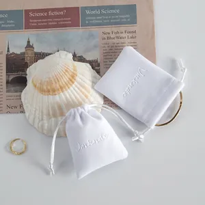 Sacchetti per gioielli in peluche bianco con coulisse e logo in rilievo su conchiglia