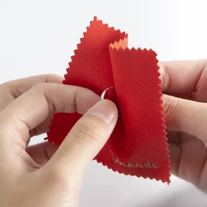Close-up view of a red microfiber cloth used for cleaning a delicate silver ring