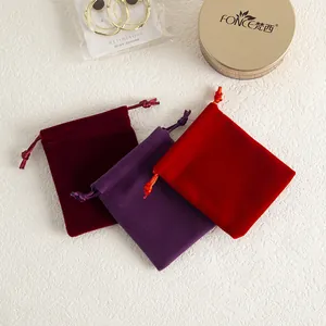 Gros plan sur des pochettes en velours rouge et violet pour le rangement de bijoux