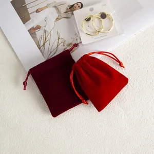 Détail macro de pochettes à cordon en velours rouge et bordeaux pour bijoux fins