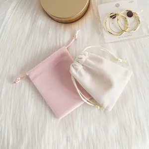 Vue détaillée des pochettes en velours rose et beige pour le rangement de bijoux fins