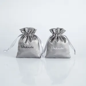 Primer plano de bolsas de satén plateado con cordón para las joyas y regalos