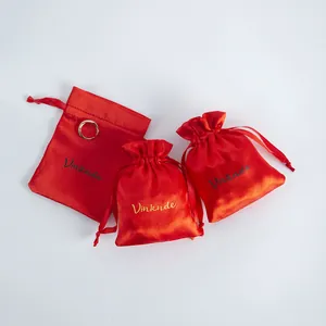 Close-up detail of vibrant red satin drawstring pouches for premium jewelry gift packaging