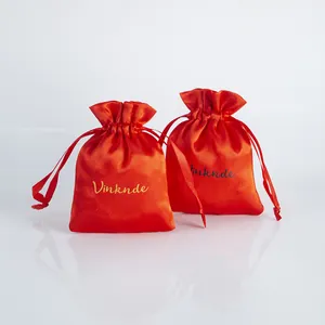 Close-up of two red satin drawstring bags with Vinknde logo for jewelry packaging