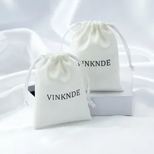 Close-up detail of cream white microfiber drawstring pouches for luxury jewelry storage