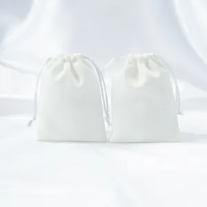 Detailed view of elegant white satin drawstring pouches for jewelry and accessories