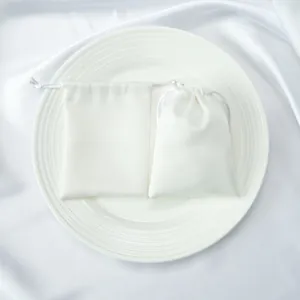 Close-up of white satin drawstring pouches for jewelry and accessories storage