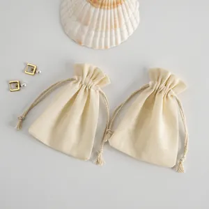 Vista detallada de dos bolsas de algodón con cordón para empaquetar joyería fina