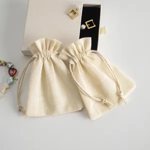 Detalle de la bolsa de algodón crema con cordón y textura de la tela
