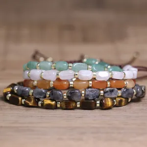 Close-up of stacked natural stone bracelets with tiger's eye and quartz beads