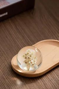 Vue détaillée en gros plan d'une boule de cristal avec fleurs séchées sur plateau