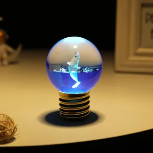 Luce notturna creativa a forma di lampadina con balena e sfera di cristallo blu.