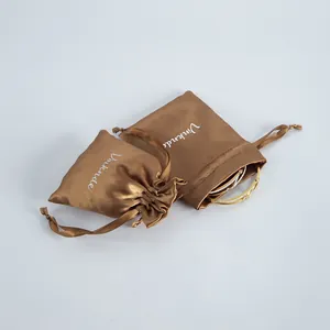 Silky brown satin drawstring jewelry pouch shown with an elegant gold bracelet