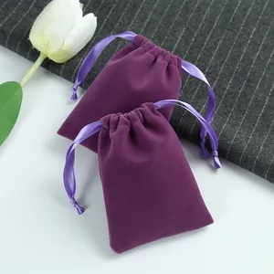 Gros plan de pochettes en velours violet à cordon pour bijoux et cadeaux