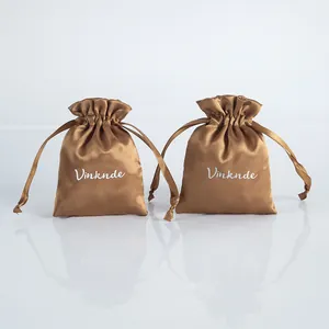 Detailed view of two elegant bronze silky satin drawstring bags for jewelry storage